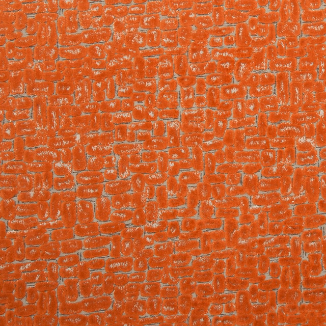 Burnt spice-orange textile with irregular raised brick-like weave and pale flecked highlights