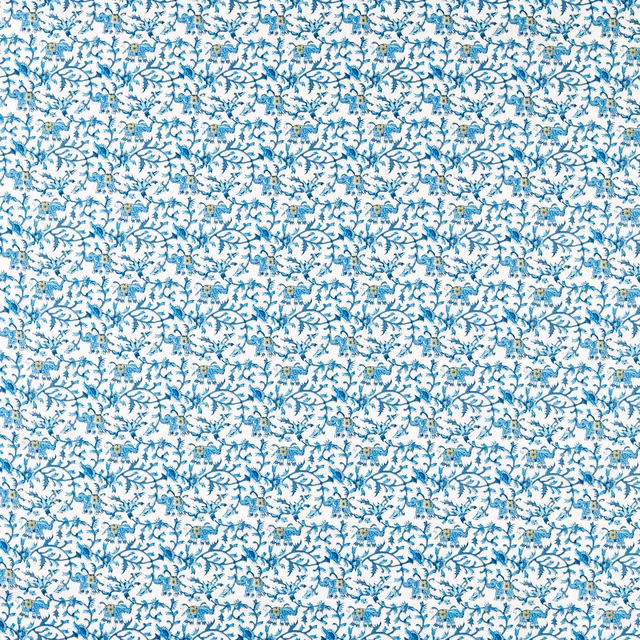 White-ground fabric with dense cobalt curling vines and tiny gold floral accents