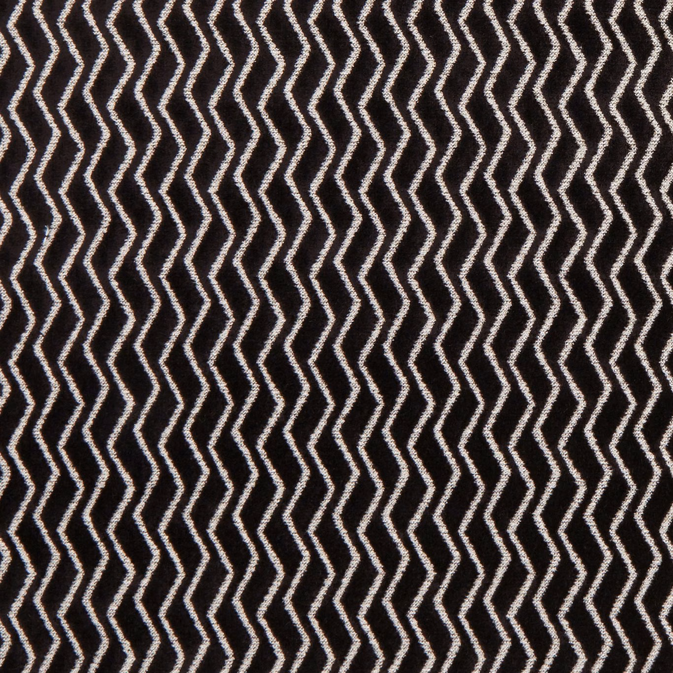 Deep ebony textile with crisp ivory zigzag rows and a tactile surface