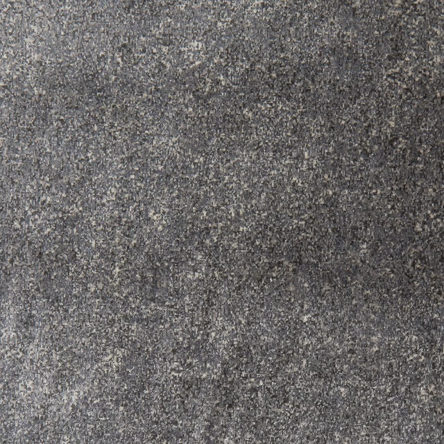 Close-up of charcoal grey woven fabric with pale flecks and mottled graphite texture