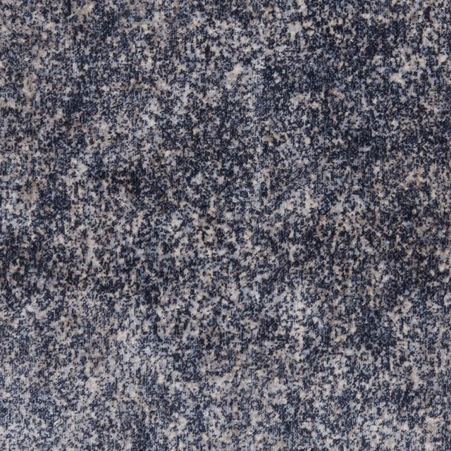 Mottled denim-blue textile with charcoal flecks and pale ivory texture