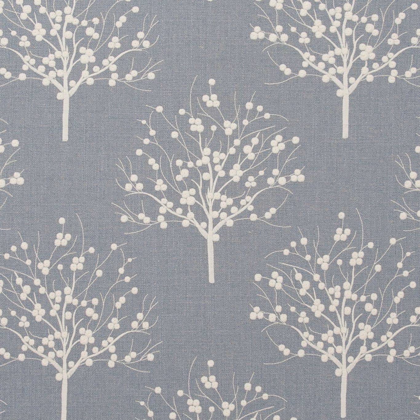 Slate chambray-blue fabric with ivory branching trees and blossom clusters