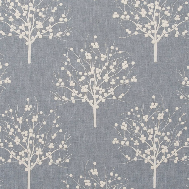 Slate chambray-blue fabric with ivory branching trees and blossom clusters