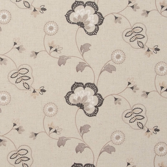 Warm charcoal floral trails and dotted petals on a pale woven ground