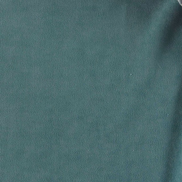 Close-up of muted mineral teal fabric with a softly directional, velvety surface