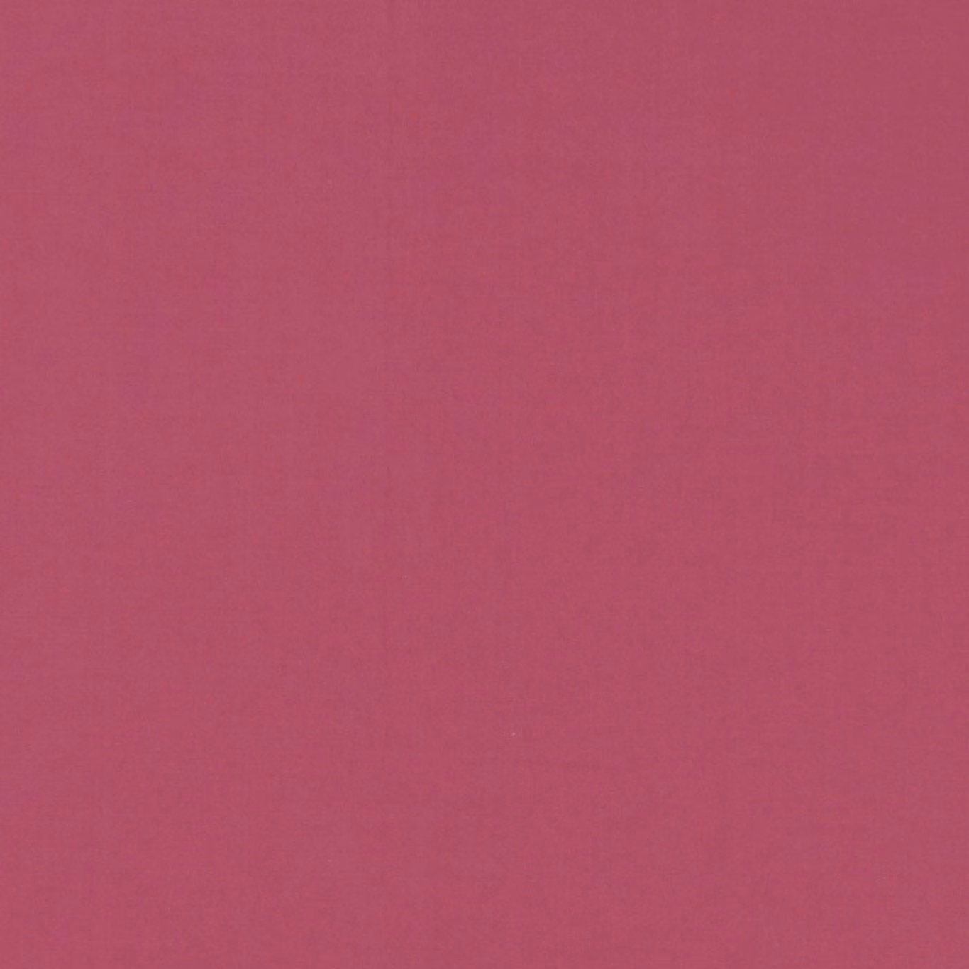 Close view of plain deep ruby-red fabric with a softly mottled fine weave