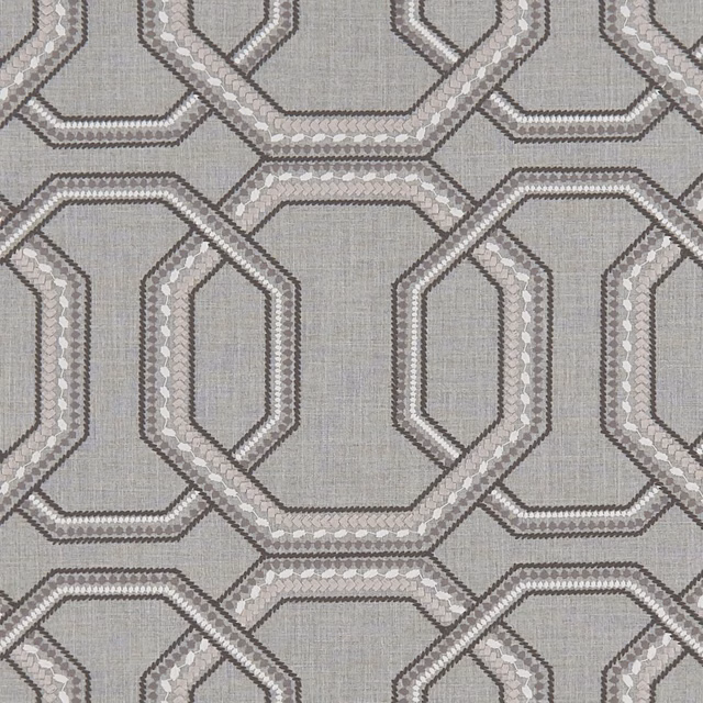 Cool charcoal-grey woven textile with interlocking octagonal bands and pale flecked highlights