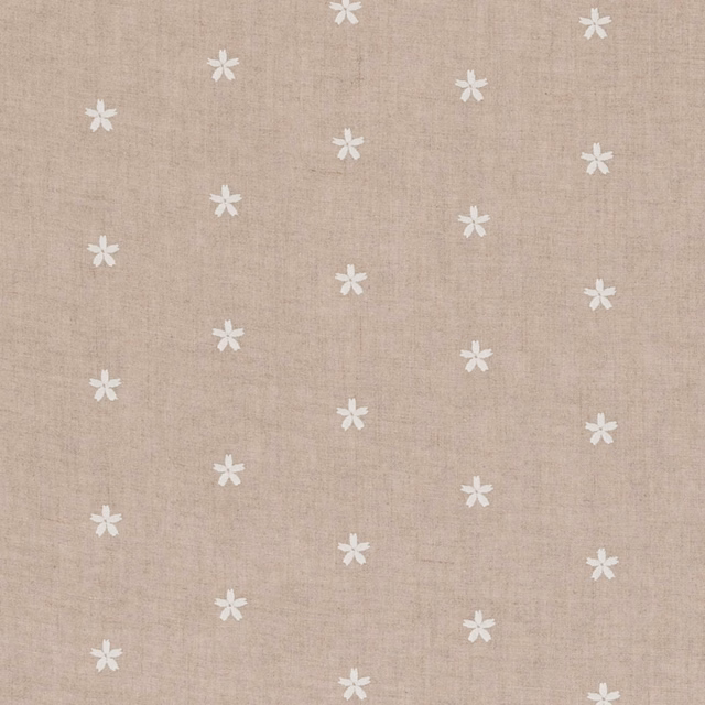 Warm beige woven fabric with scattered small white flower motifs and subtle natural texture