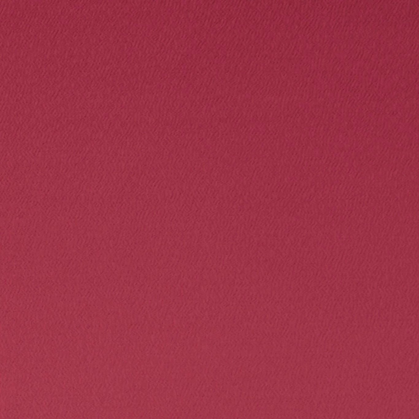 Close-up of saturated fuchsia fabric with a fine, softly rippled woven texture