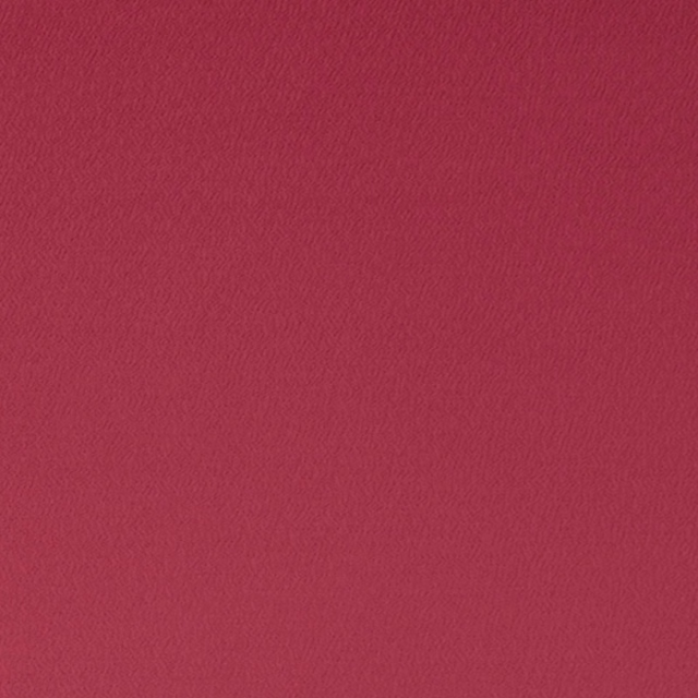 Close-up of saturated fuchsia fabric with a fine, softly rippled woven texture