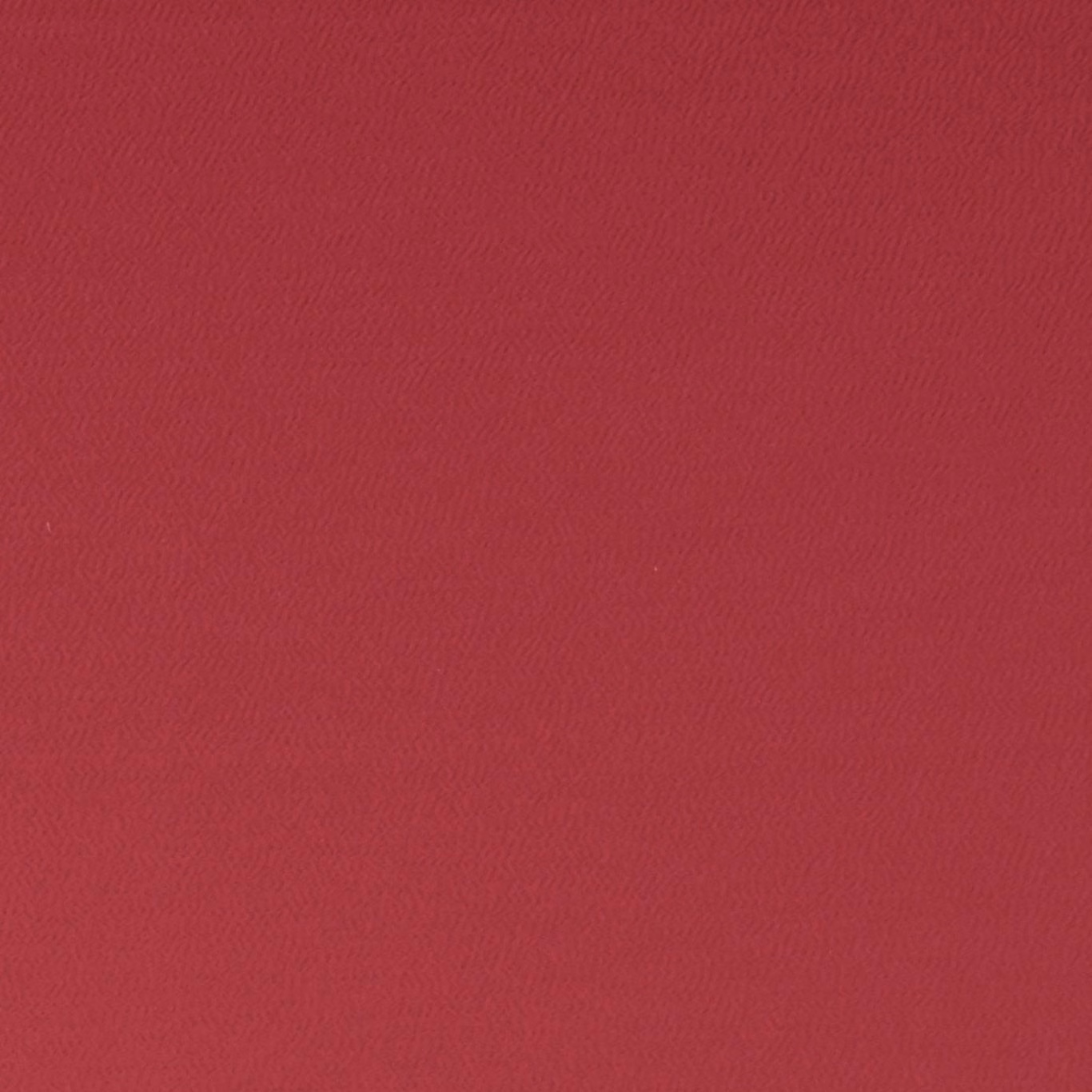 Close-up of deep ruby red fabric with a fine, softly rippled weave