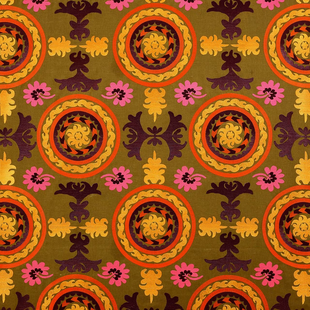 Olive green patterned fabric with circular medallions, pink florals and plum motifs