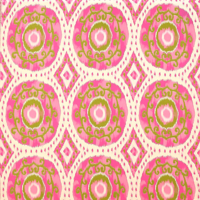 Bright fuchsia patterned fabric with green circular medallions and cream diamond accents