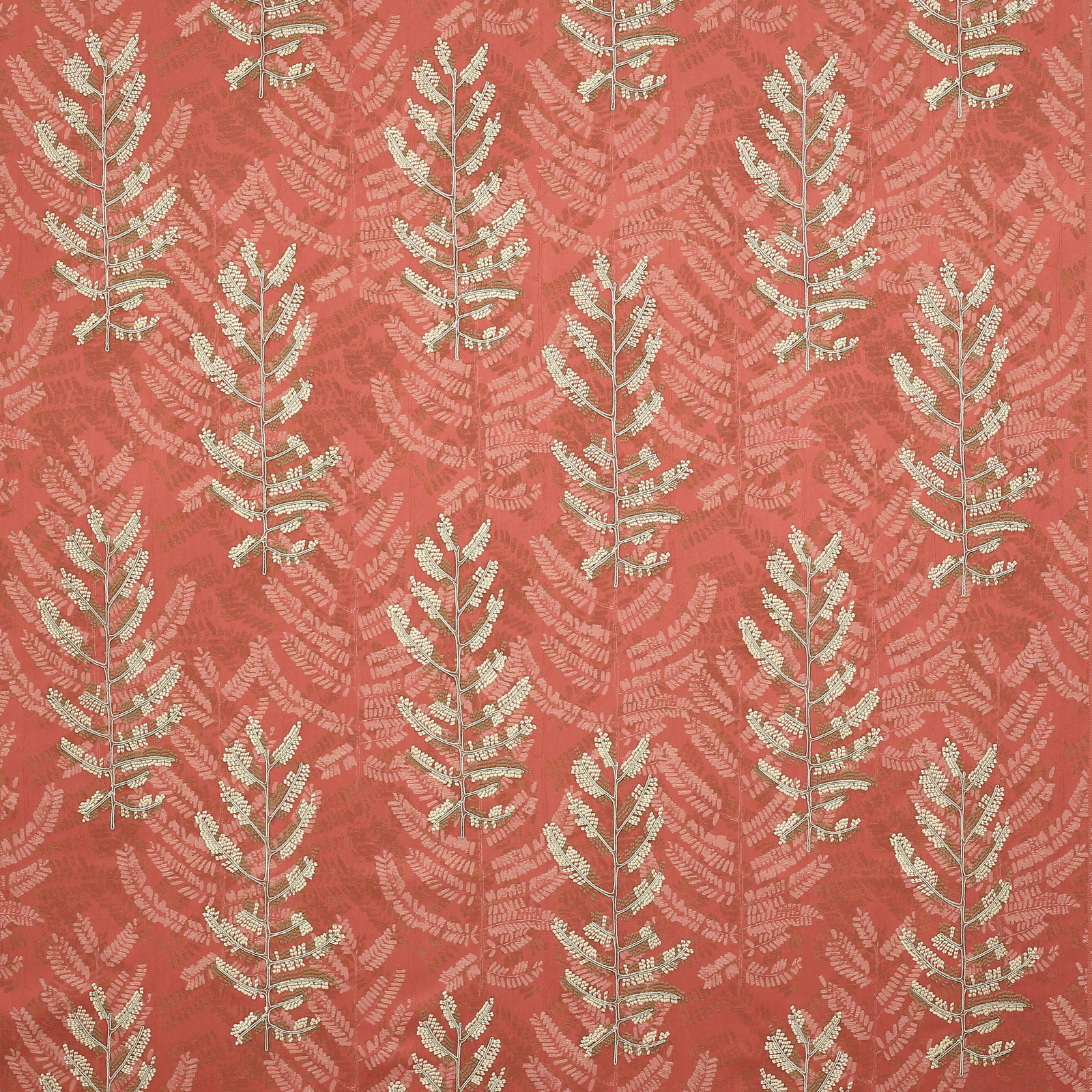 Coral-red botanical fabric with pale leaf motifs and textured woven surface