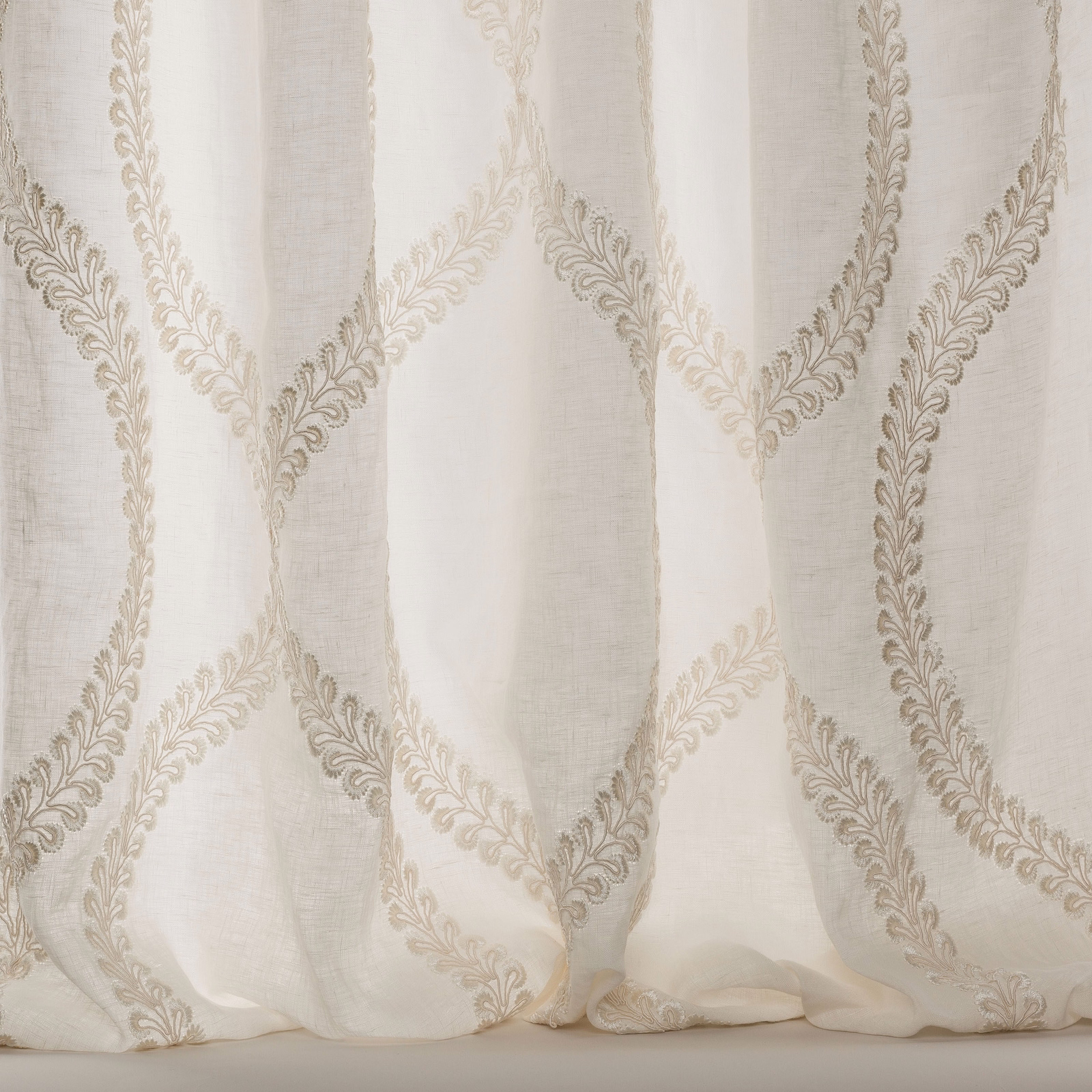 Ivory sheer fabric with large scrolling embroidered motif and soft linen texture