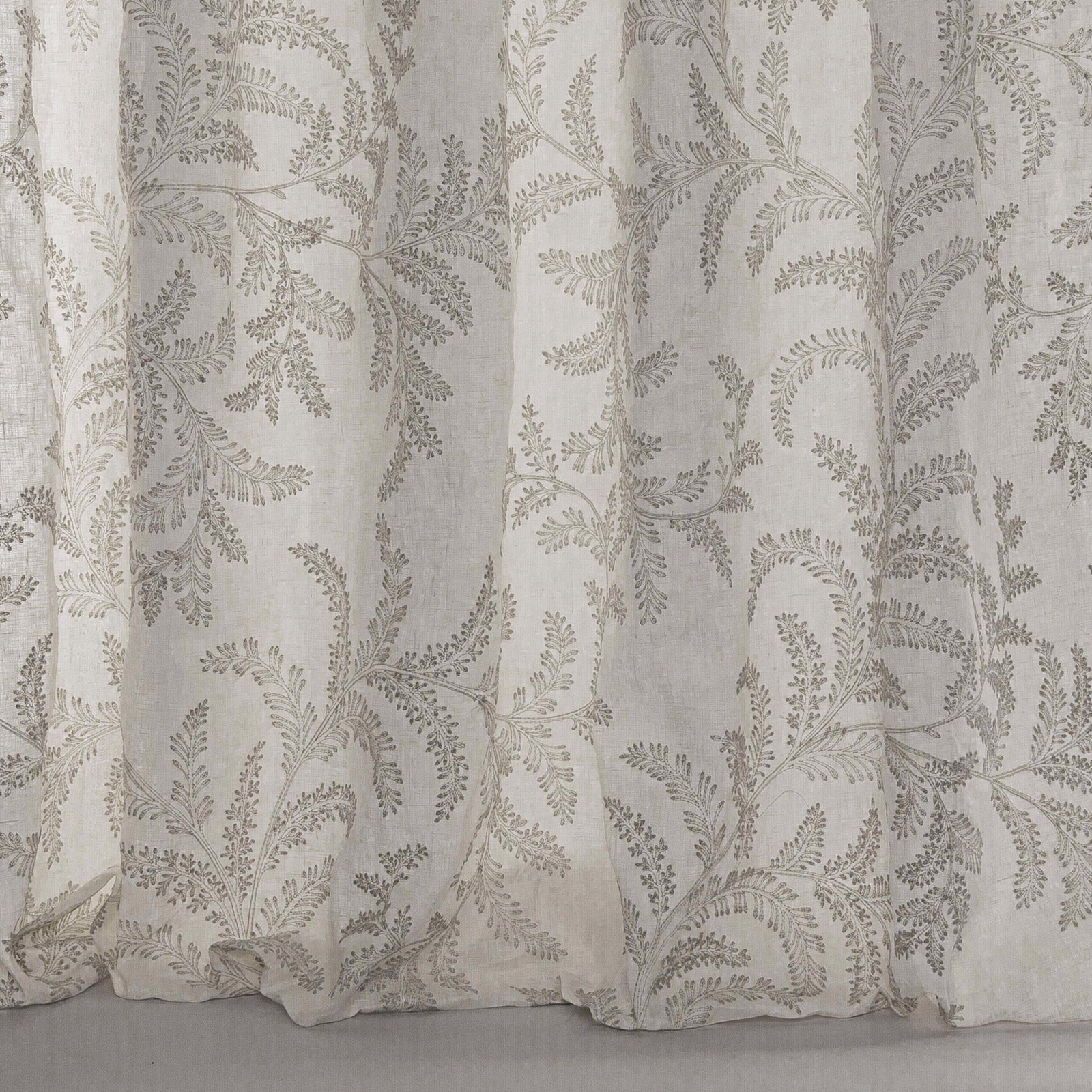 Pale silver-grey linen fabric with delicate botanical leaf trailing and soft drape