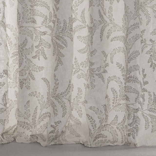 Pale silver-grey linen fabric with delicate botanical leaf trailing and soft drape