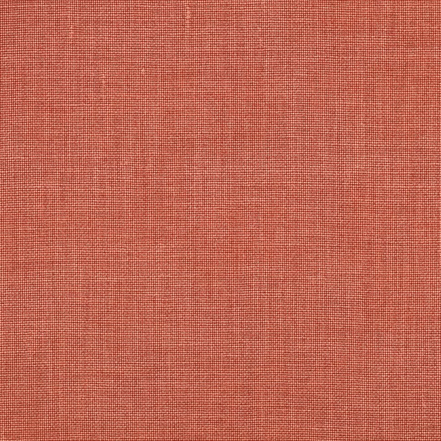 Close-up of warm tomato-red plain woven linen fabric with fine texture