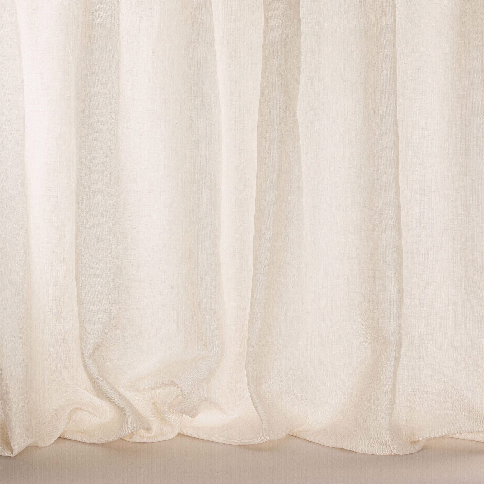 Pale ivory sheer curtain fabric with a softly textured linen weave and gentle folds