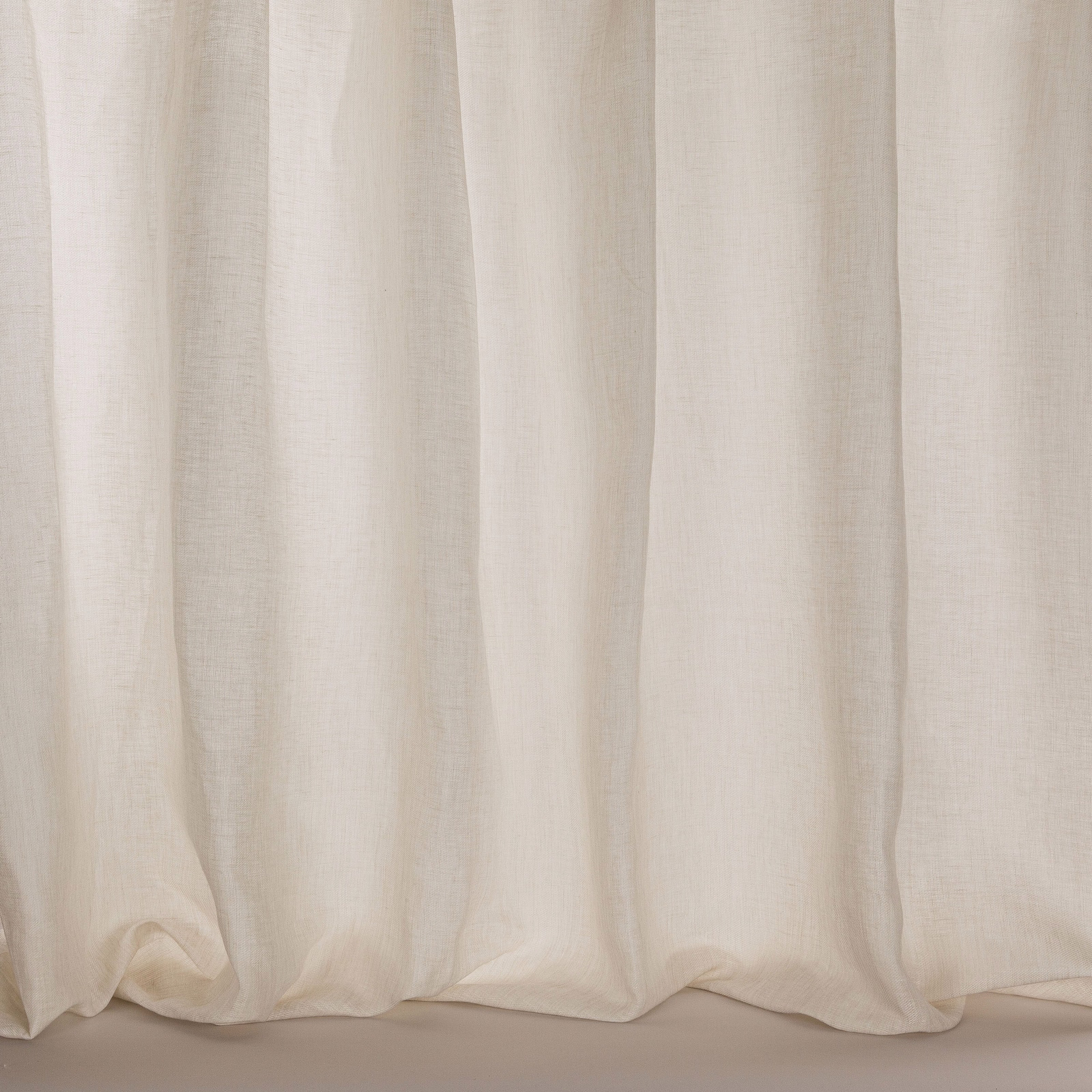 Pale warm taupe sheer fabric hanging in soft vertical folds