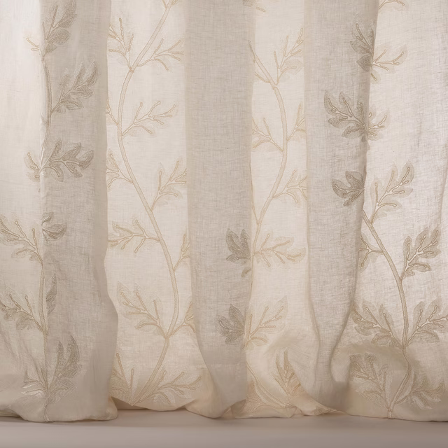 Sheer ivory embroidered curtain fabric with trailing leaf motif and soft silver tone