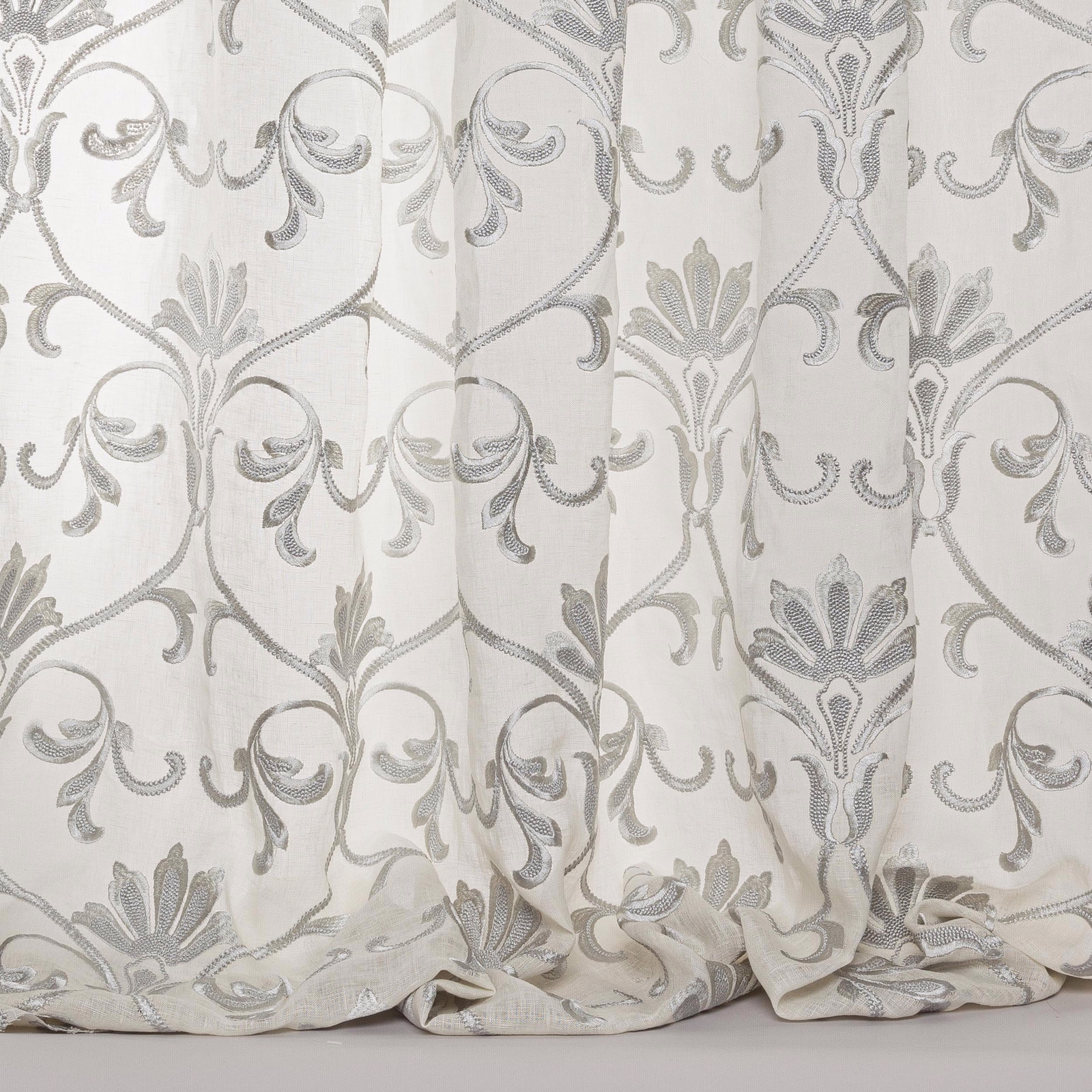 Sheer blue-grey damask fabric with ornate scrolling motif and soft drape