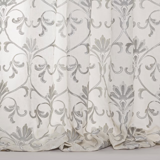 Sheer blue-grey damask fabric with ornate scrolling motif and soft drape