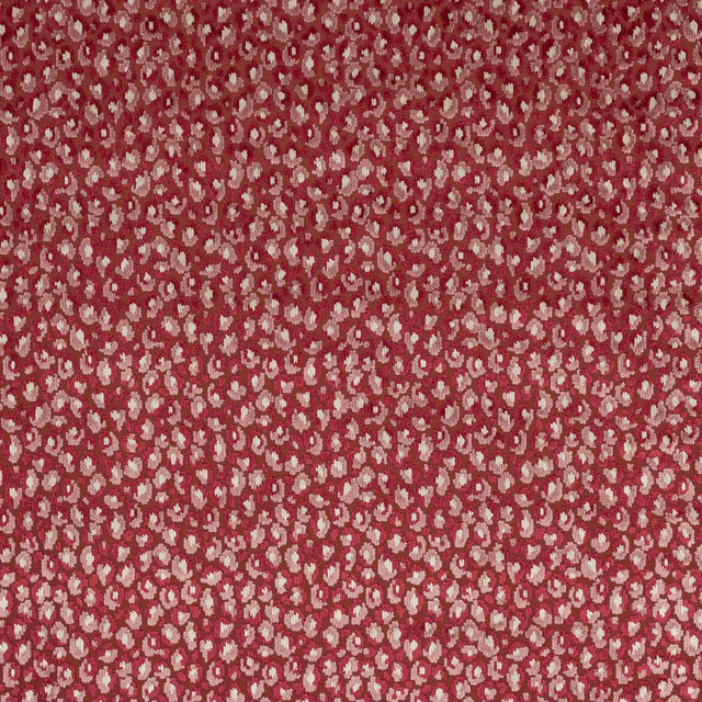 Close-up of small cream floral motifs on a warm ruby-red woven fabric