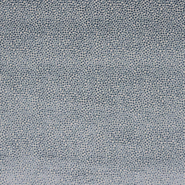 Close-up of soft powder-blue speckled woven fabric with fine textured dots