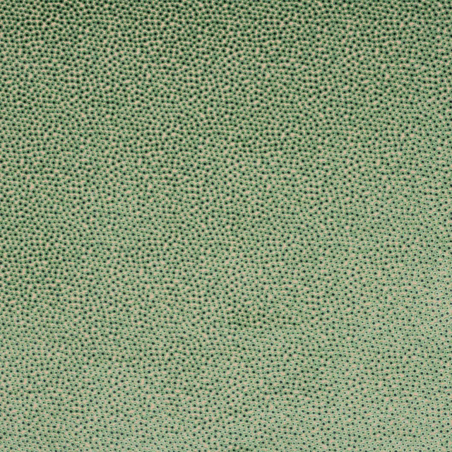 Soft sage green woven fabric with fine dark dotted pattern