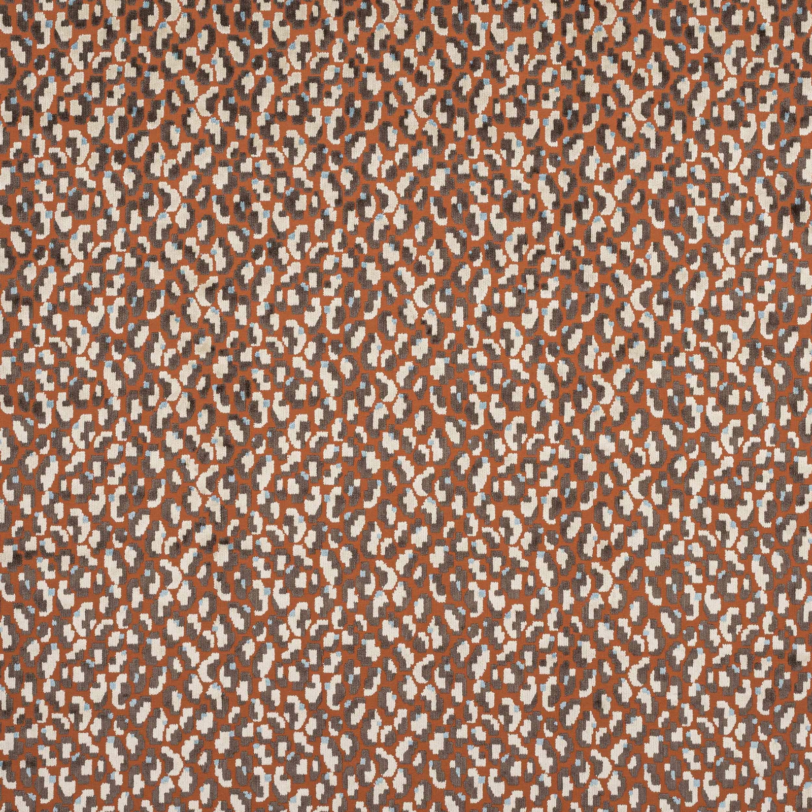 Abstract small-scale terracotta and ivory spotted fabric on a warm brown ground