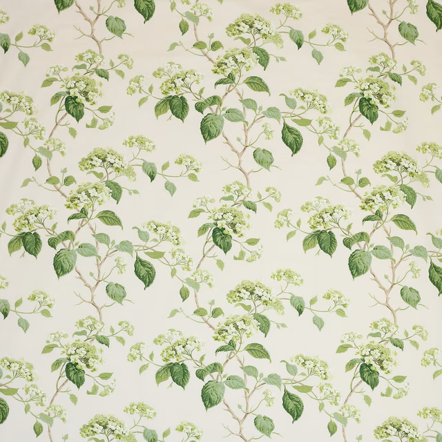 Botanical cotton fabric with green leaves and pale blossom sprigs on ivory