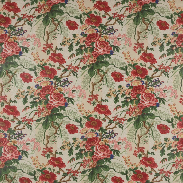 Red and pink floral cotton with green leafy branches on a cream ground