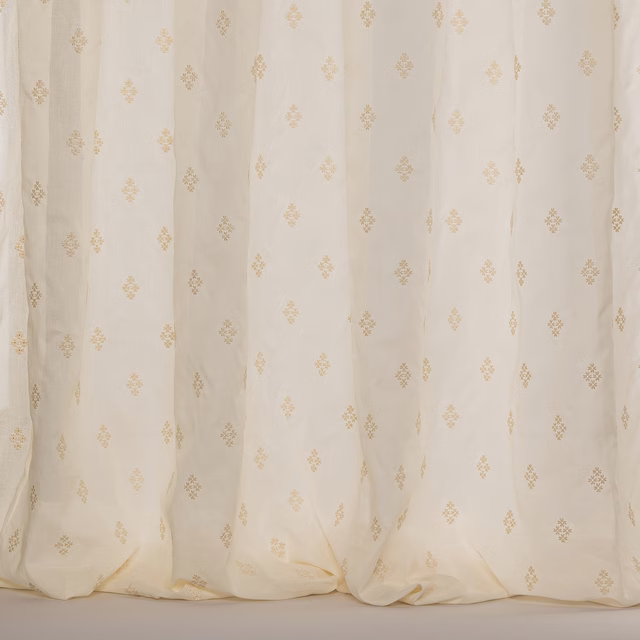 Cream sheer curtain fabric with tiny damask motifs and soft vertical folds