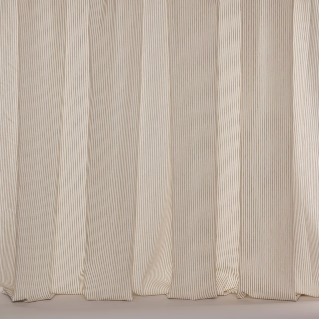 Wide cream-beige sheer fabric with fine vertical pinstripes hanging in soft folds