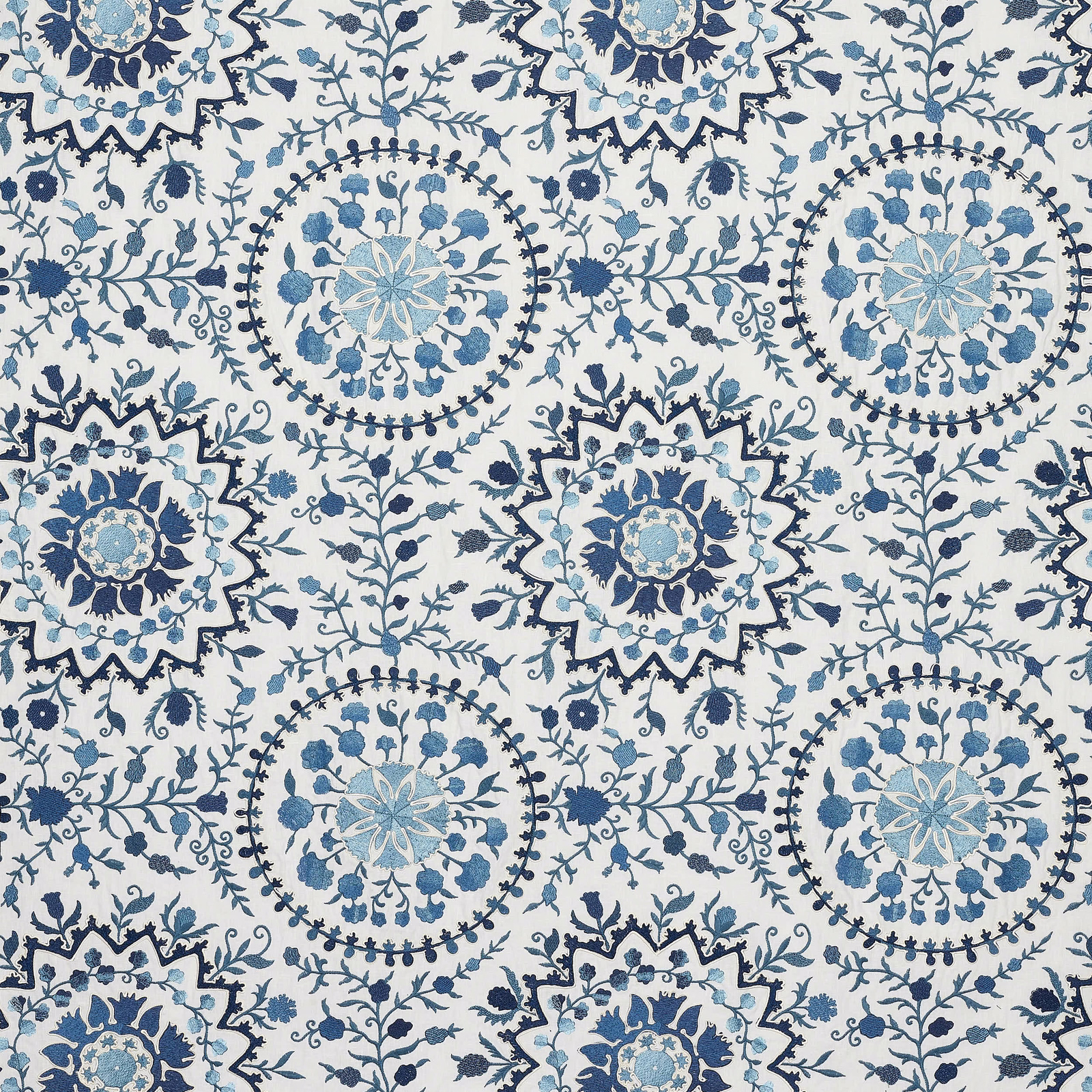 Blue and indigo floral medallion fabric on a pale ground, repeating large decorative motifs