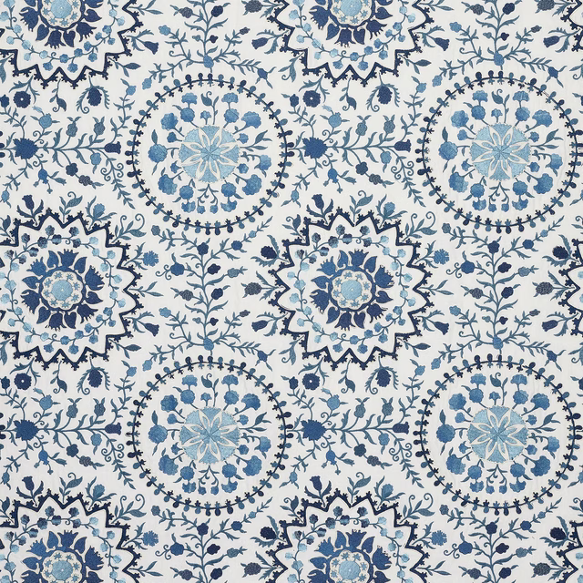 Blue and indigo floral medallion fabric on a pale ground, repeating large decorative motifs