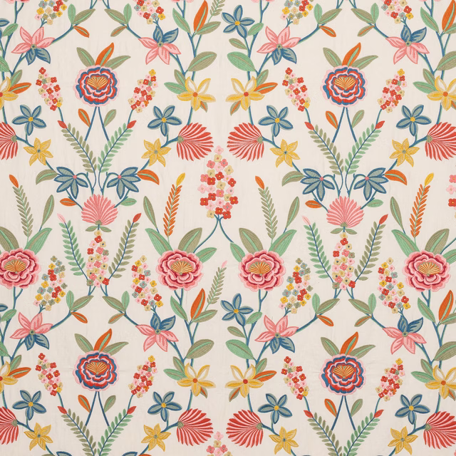 Floral botanical fabric on ivory ground with pink, green, blue and yellow blooms