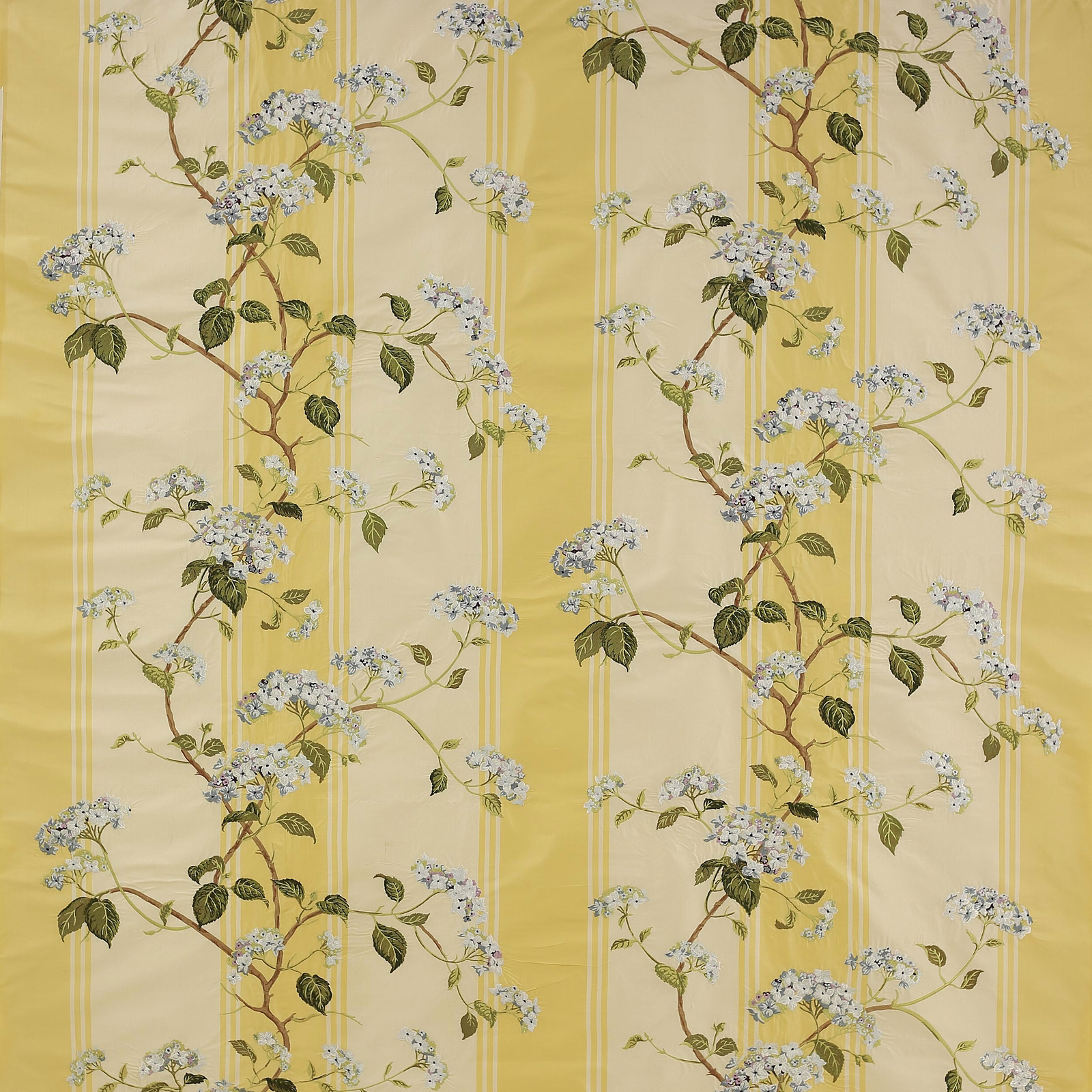 Yellow botanical silk fabric with blossom branches, green leaves and pale blue flowers