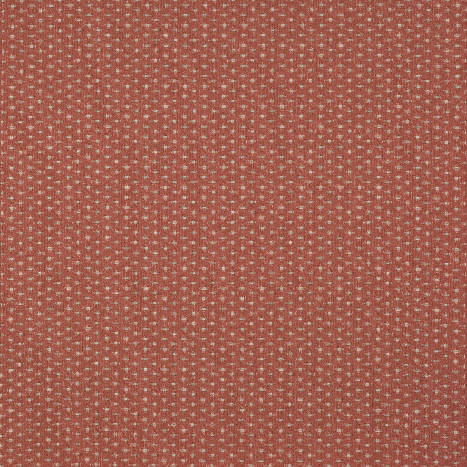Coral terracotta woven fabric with tiny pale dot motif on a textured ground