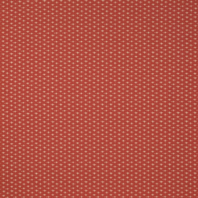 Close-up of small geometric woven fabric in warm coral red with pale speckled highlights