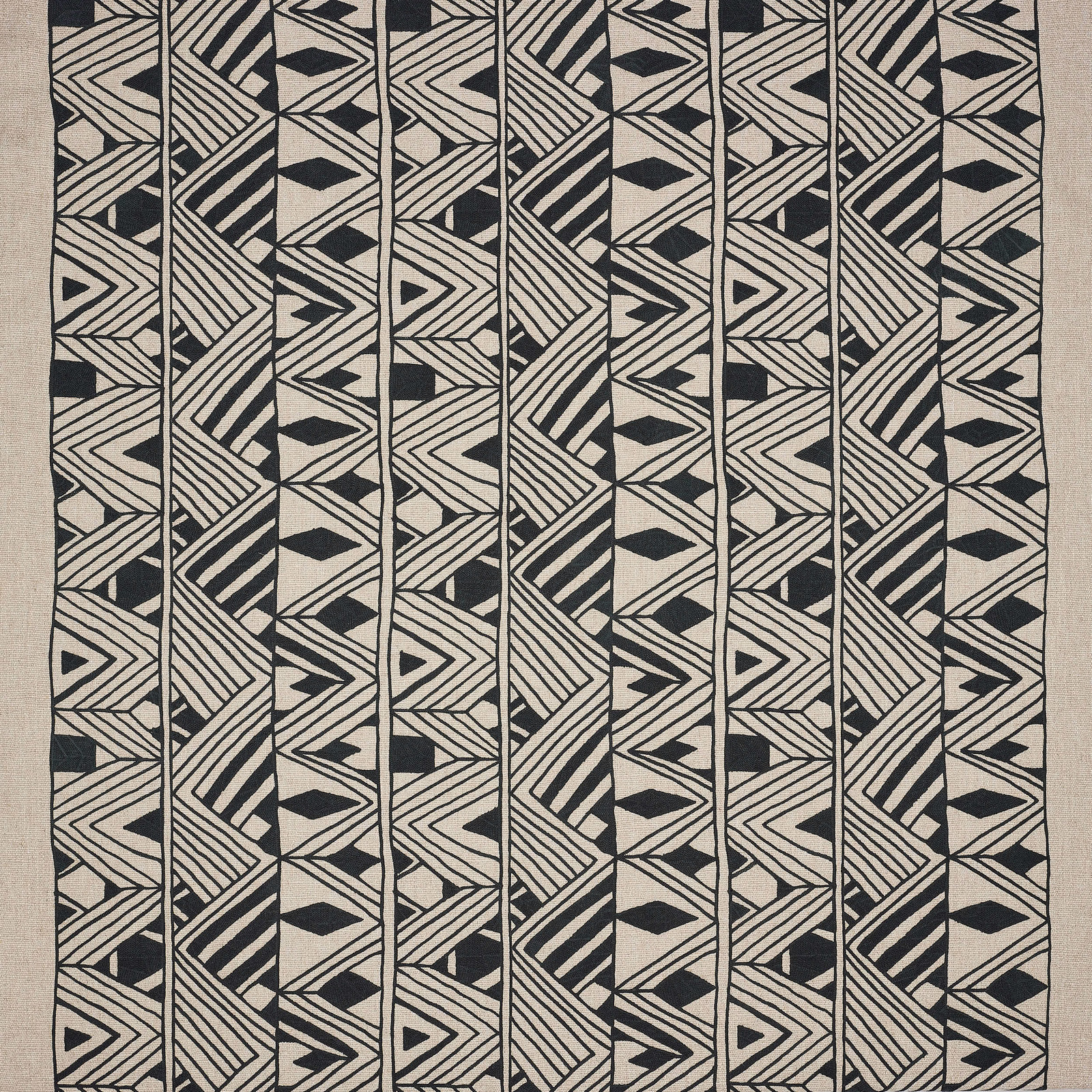 Black geometric stripe and diamond fabric swatch on a pale linen ground
