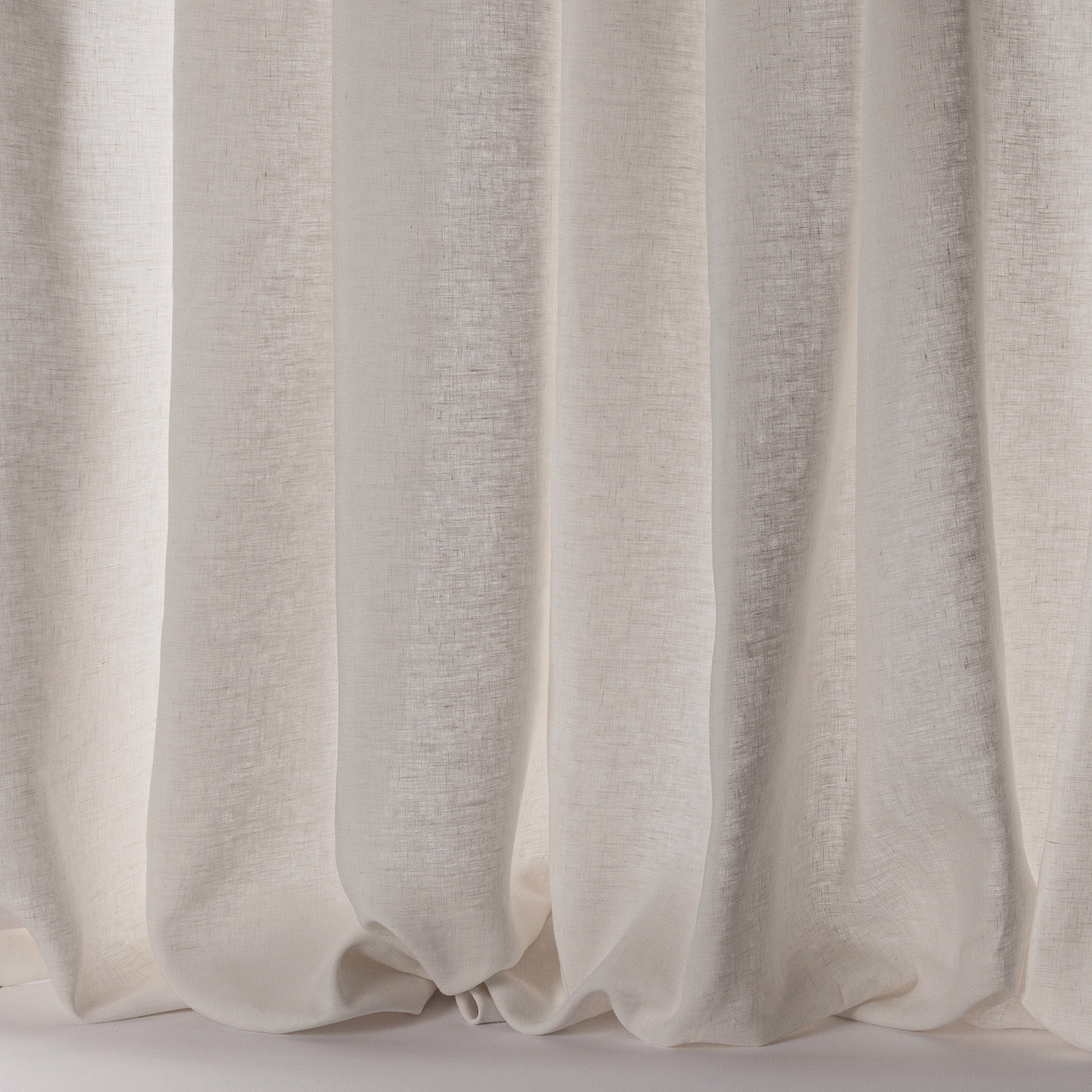 Soft ivory linen sheer curtains hanging in relaxed vertical folds