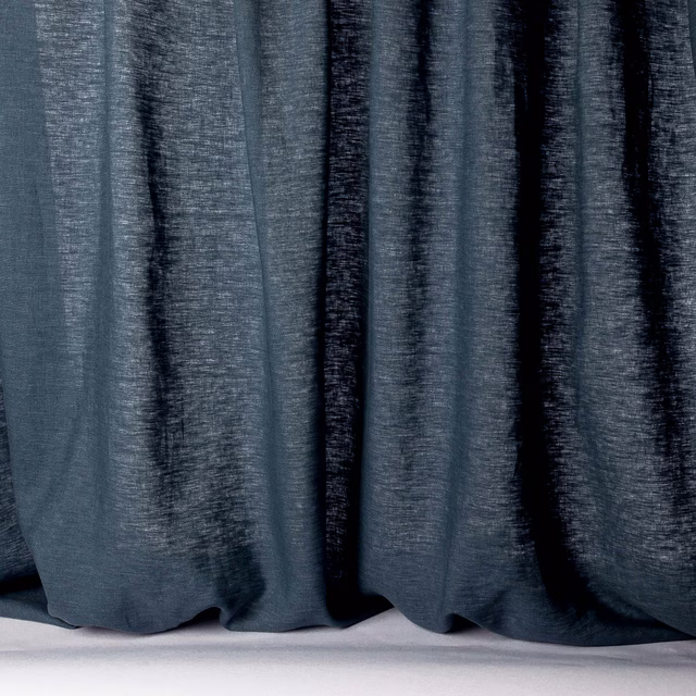 Deep navy linen sheer fabric hanging in soft vertical folds