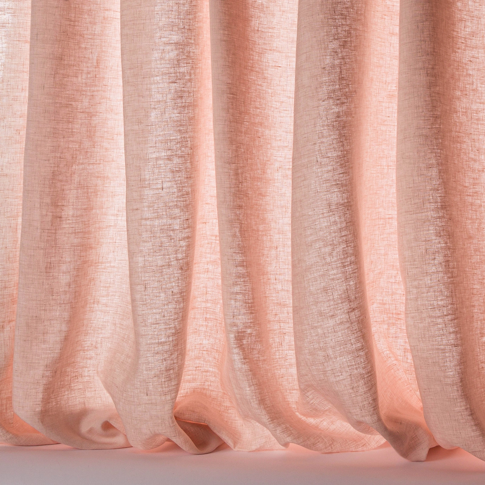 Soft peach-pink linen sheer fabric with a loose, slubbed weave and fluid folds
