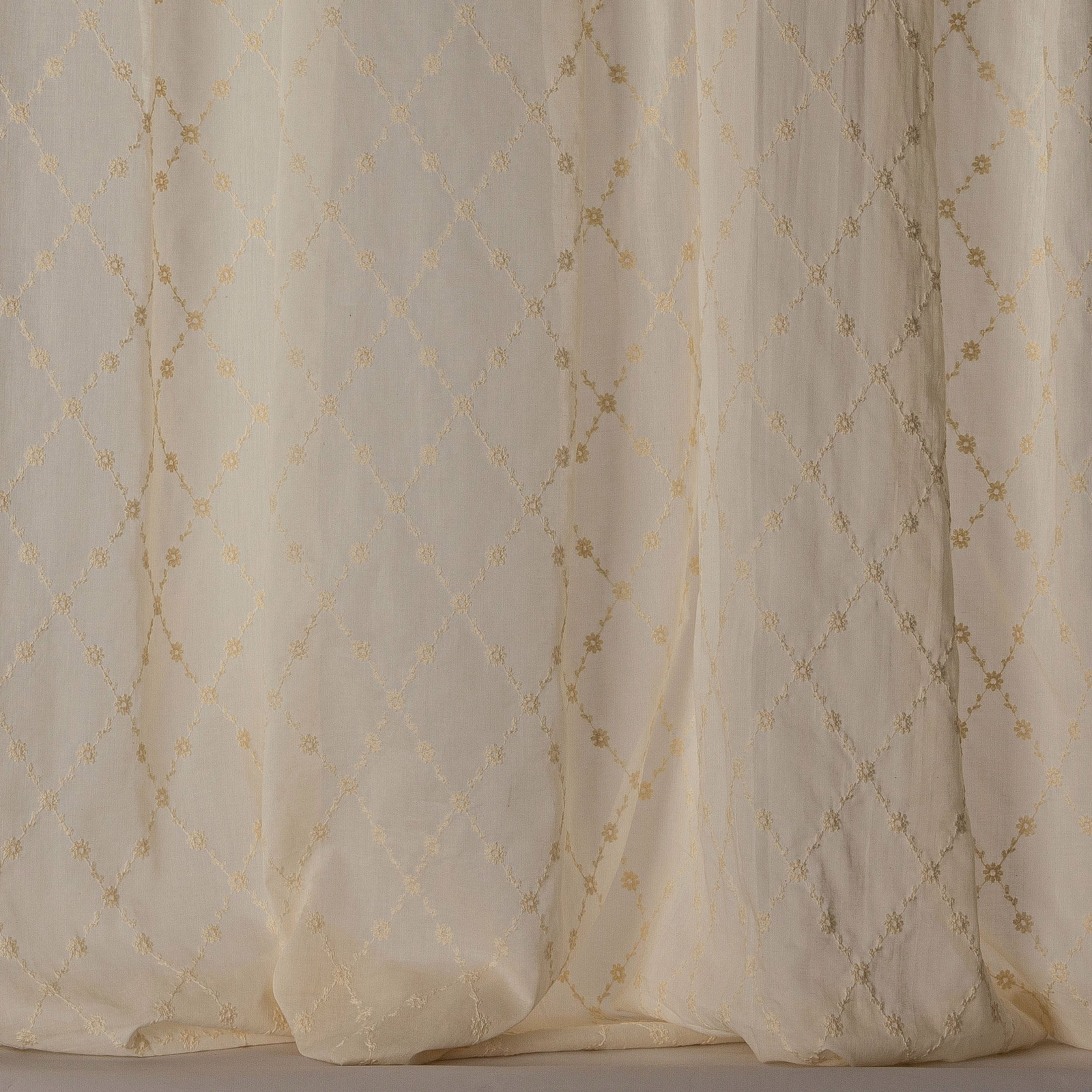 Cream sheer curtain fabric with soft gold trellis and tiny floral intersections
