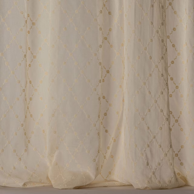 Cream sheer curtain fabric with soft gold trellis and tiny floral intersections