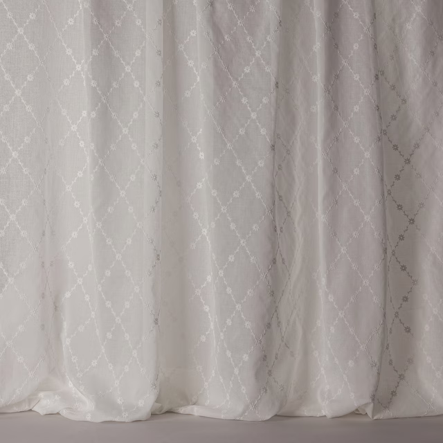 Soft white sheer curtain fabric with a subtle trellis lattice pattern