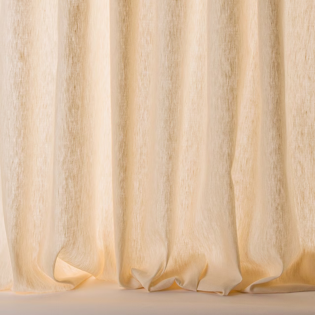 Sheer cream linen-blend curtain with soft vertical folds and warm glow