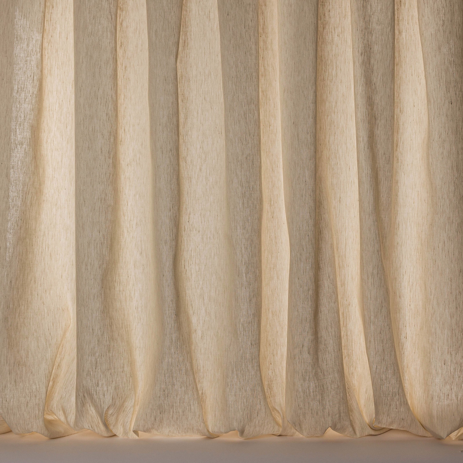 Soft warm cream sheer fabric hanging in vertical folds with a subtle linen slub